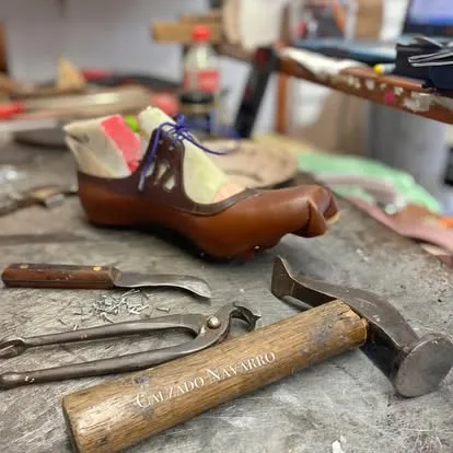 Zapato Navarro montado sobre la horma junto a las herramientas del taller