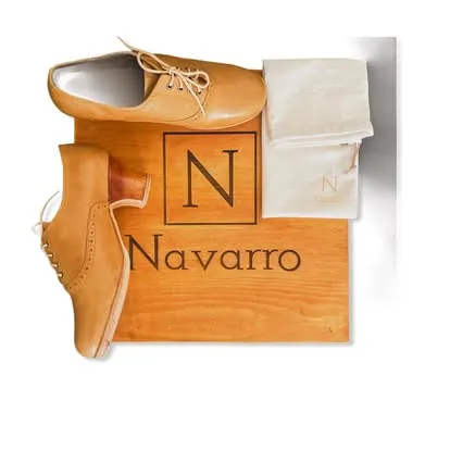 Zapato coñac de Navarro junto a la caja de madera y la bolsa de tela con logo